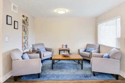 a living room with three couches and a coffee table